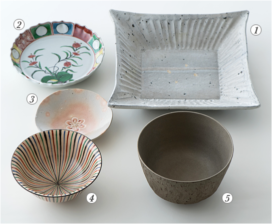 写真:主菜用の白い角皿、副菜用は複数の色が使われている華やかな丸皿、香の物用は薄紅色の丸皿、ご飯用は器の淵から茶碗の中心に向かって、赤・青・緑・紺色のストライプが入っている、汁物用は濃いグレーのお椀